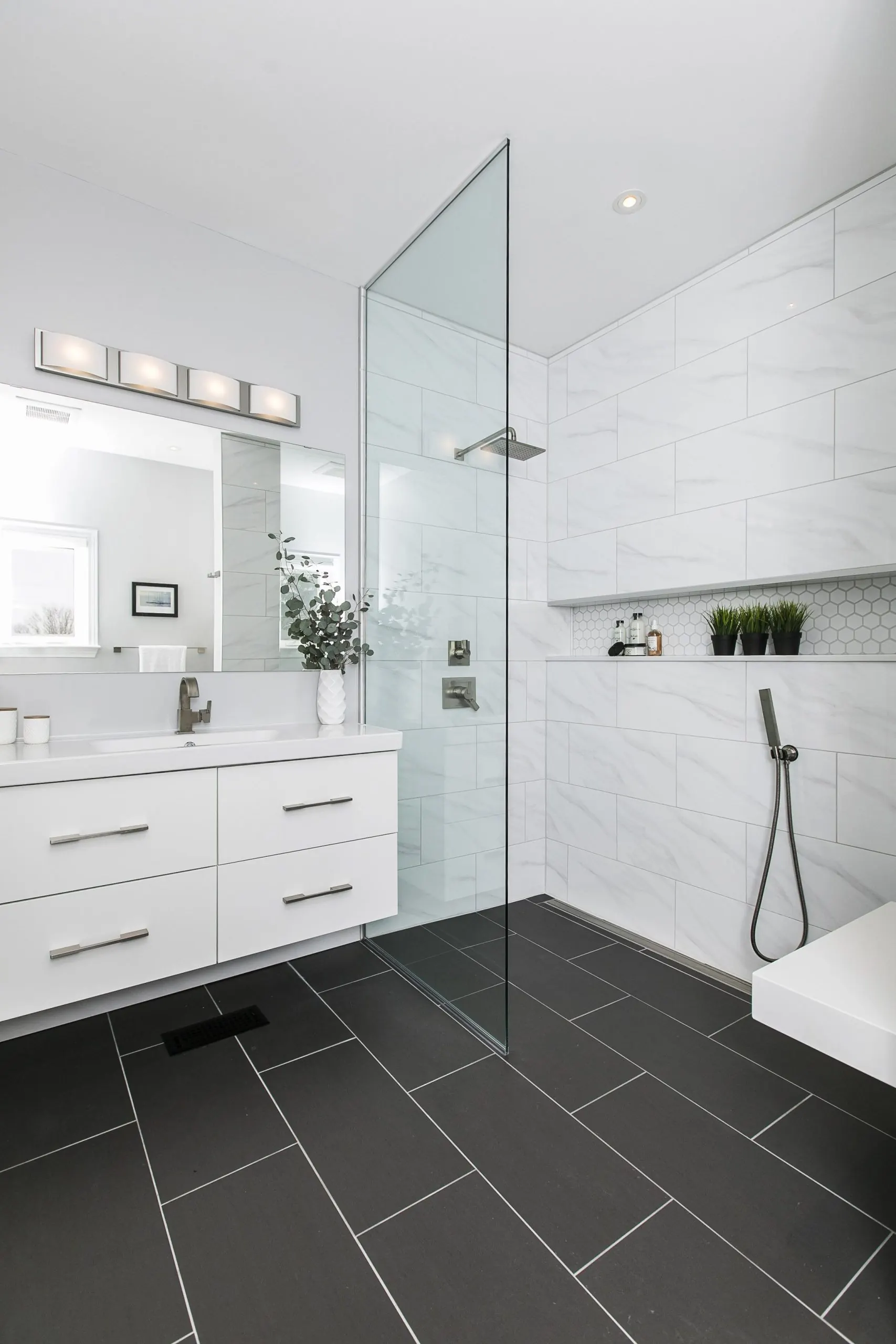 Walk-in shower and large white wall tile in a bright bathroom