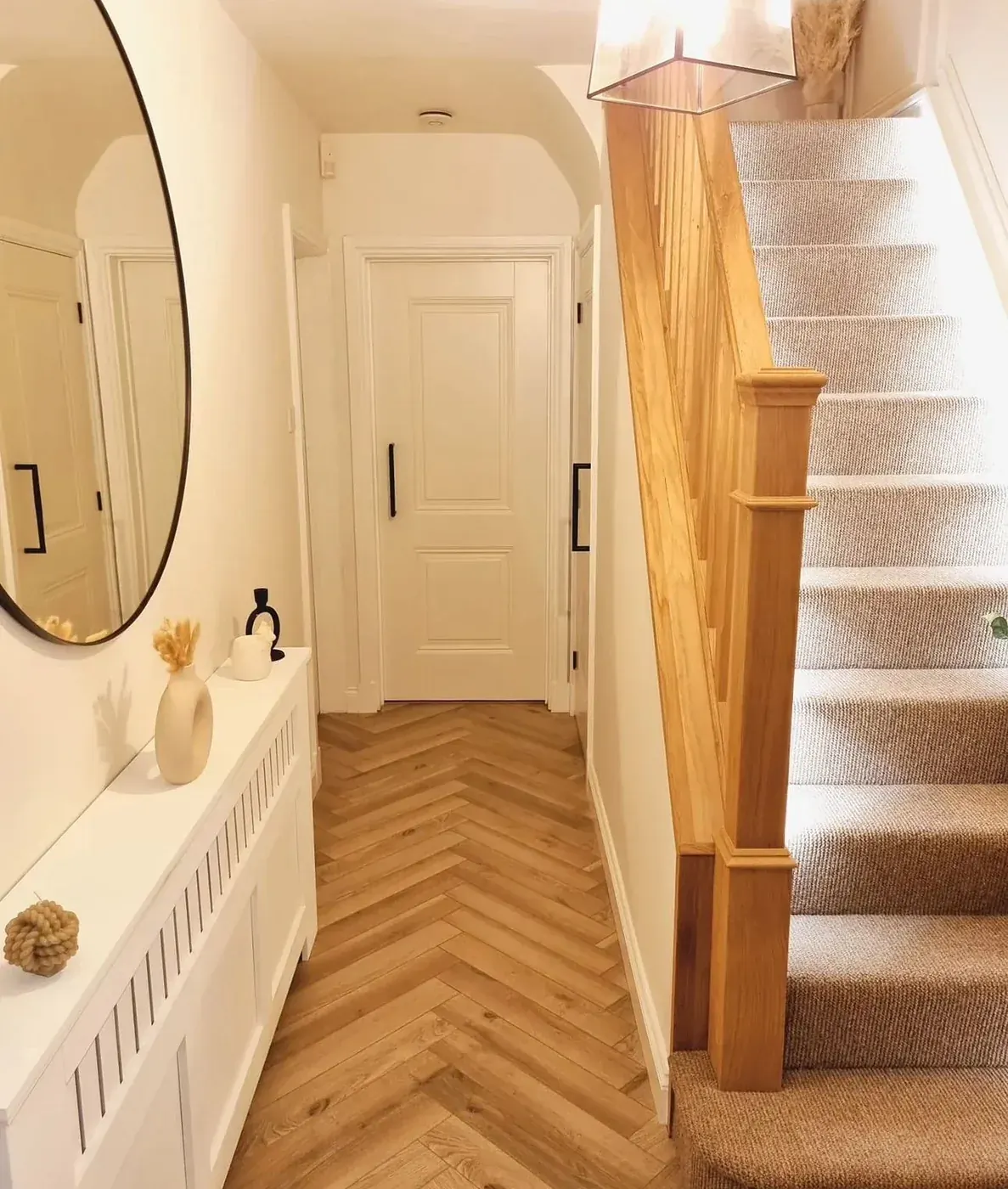 Chevron hardwood in a front hallway next to a staircase
