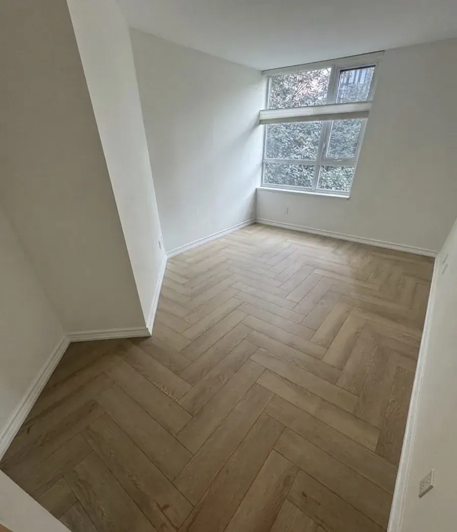 Empty bedroom with a herringbone laminate floor
