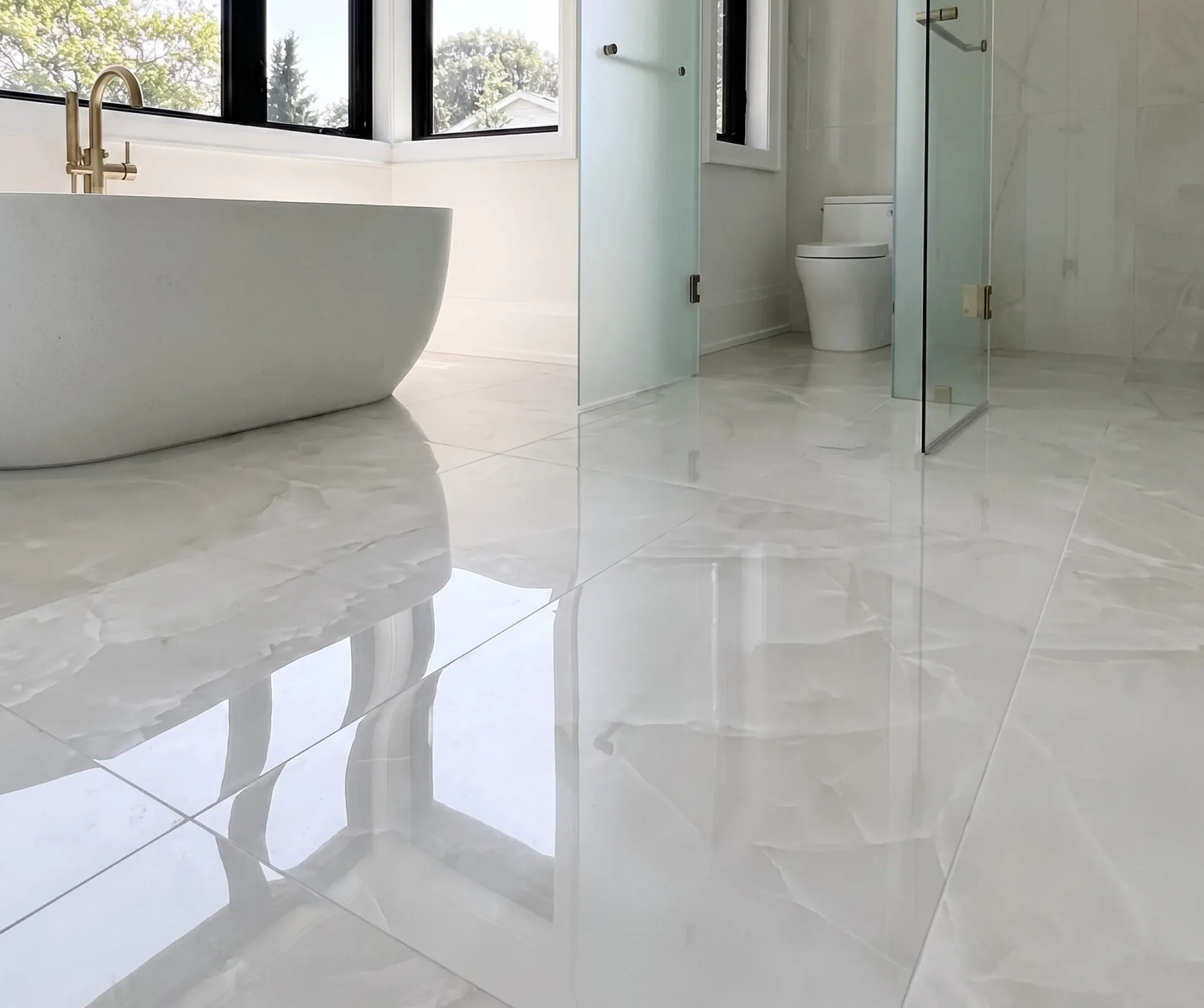 Modern bathroom in big polished porcelain tiles with a marble look