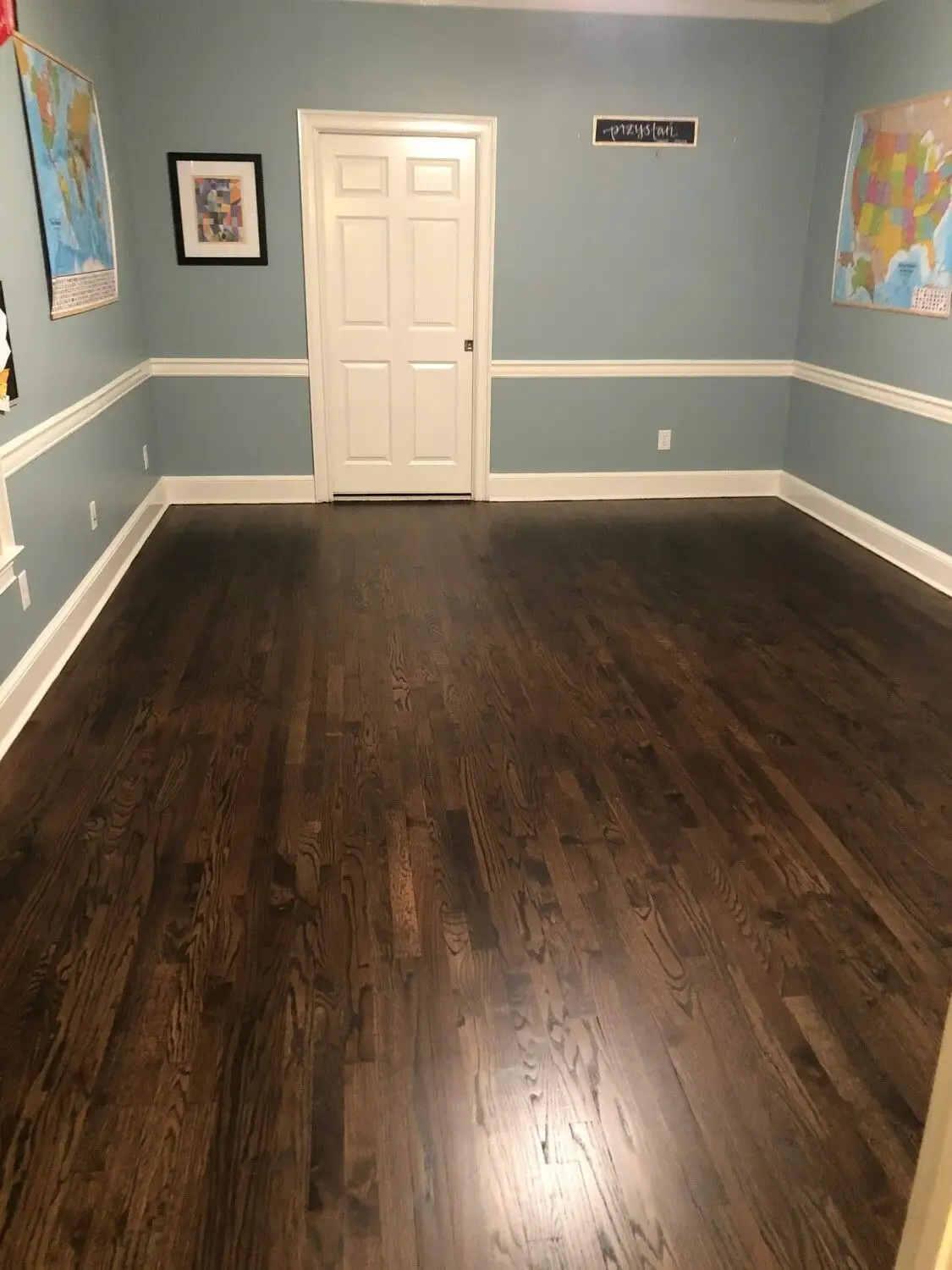 Empty dining room with refinished dark hardwood