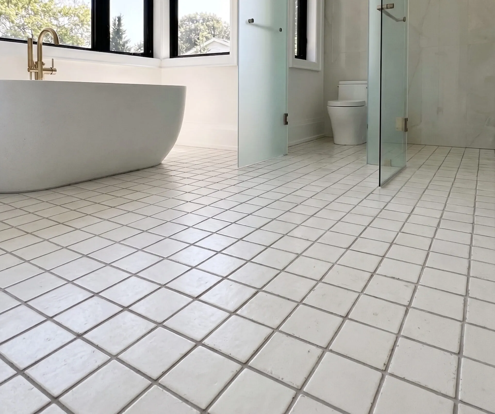 The same bathroom before, in small square white tiles