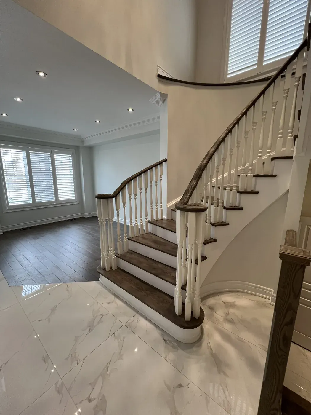 Curved staircase with dark treads and painted turned spindles