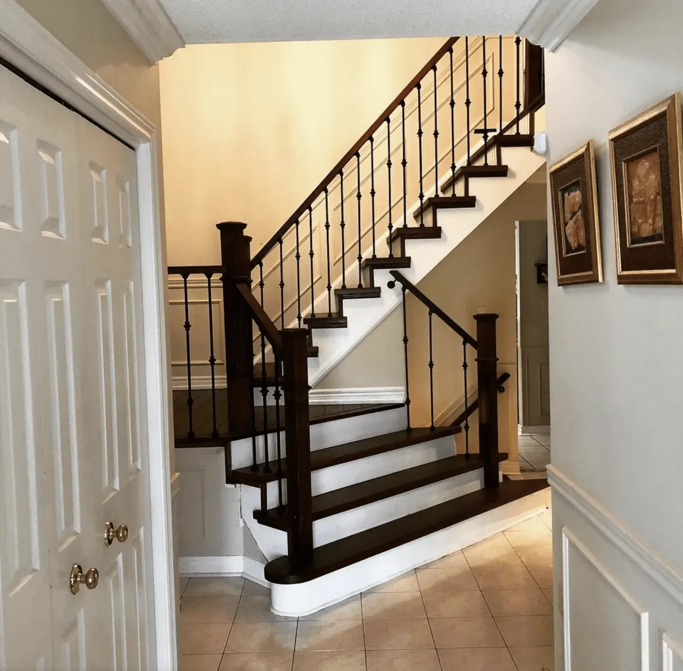 Staircase with dark treads, white risers and iron pickets