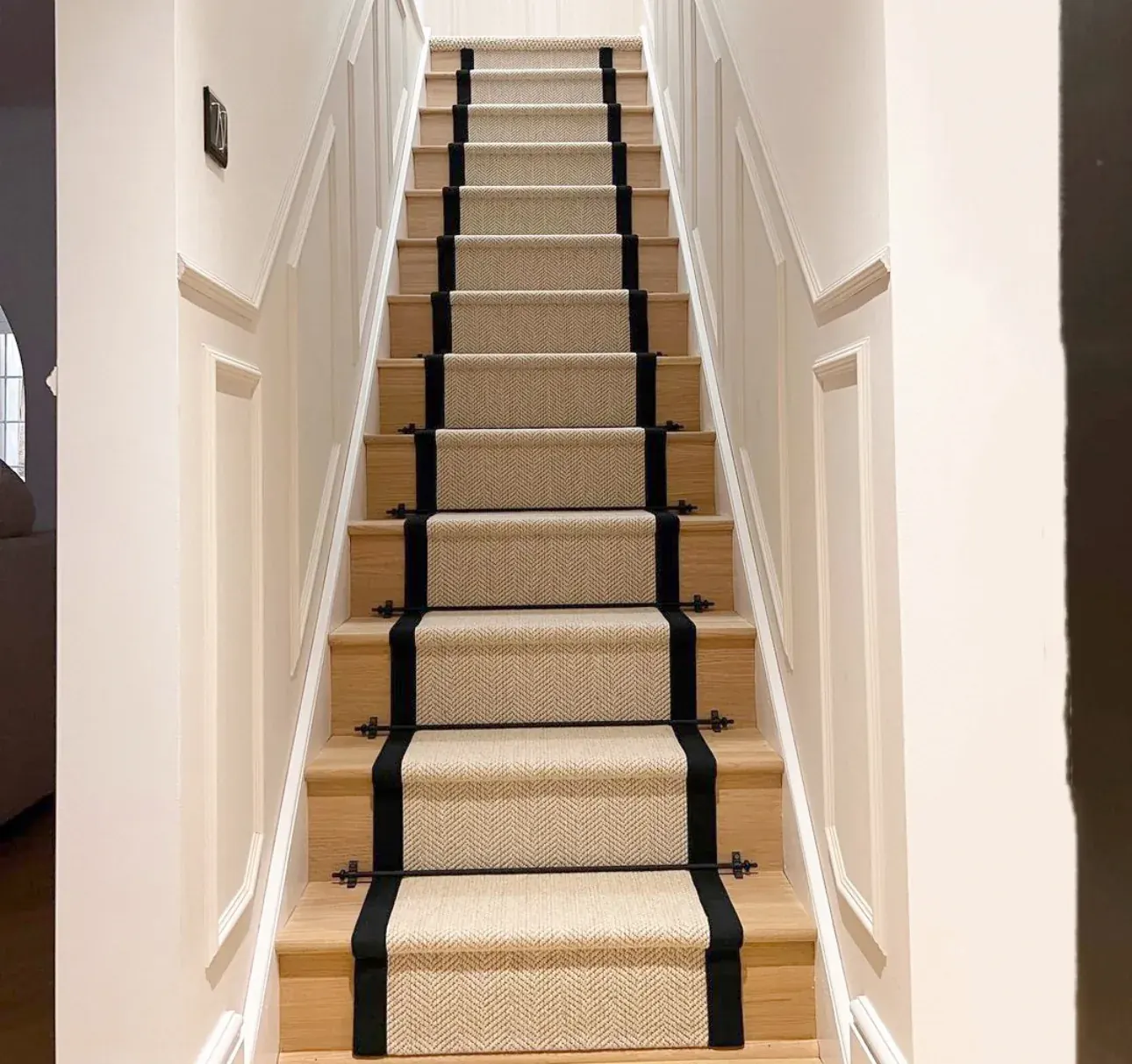 Staircase with a centre carpet runner, pale oak treads and white risers
