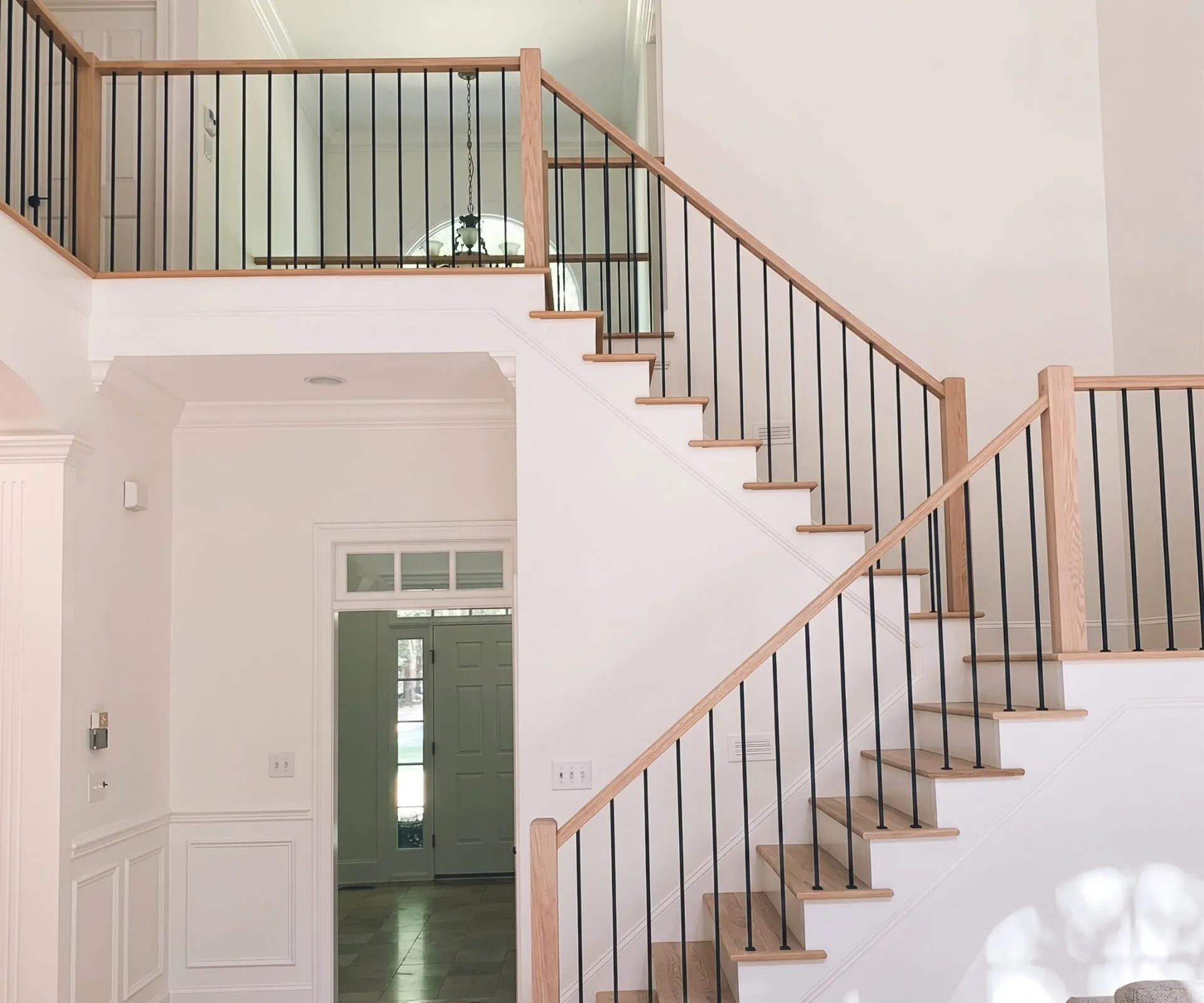 Finished staircase with oak treads, an oak rail and black metal spindles