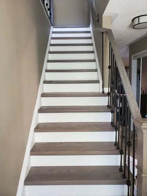 Stained treads and white risers with iron spindles