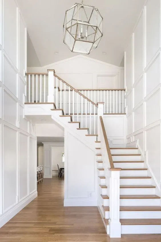 Oak treads on a white staircase in a two-storey entry
